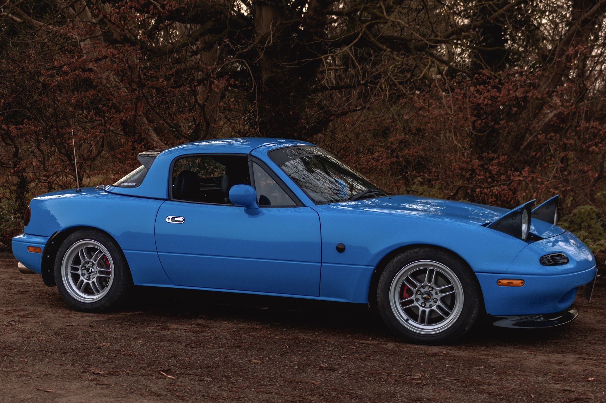 Blue Mazda MX-5 roadster, side profile